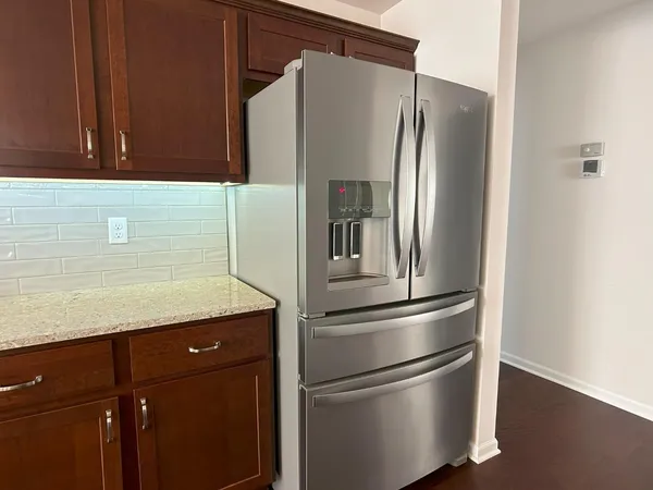 a metallic refrigerator freezer sitting in a kitchen