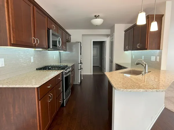 a kitchen with stainless steel appliances granite countertop a sink stove and cabinets