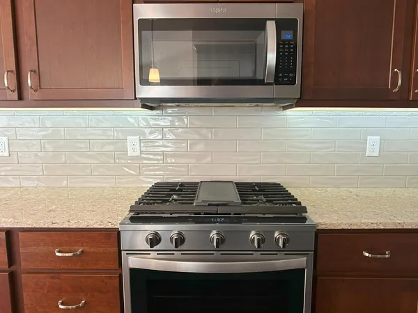 a stove top oven sitting inside of a kitchen