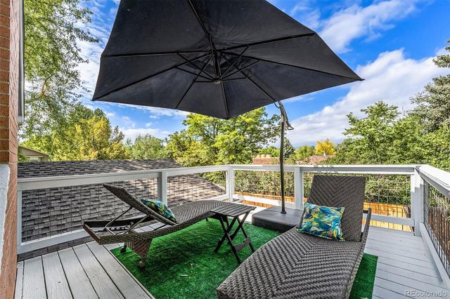 a view of balcony with furniture and umbrella