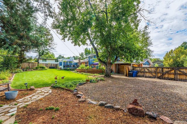 a view of a house with backyard and trees