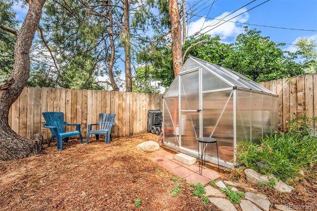 a view of backyard with a table and chairs and wooden fence