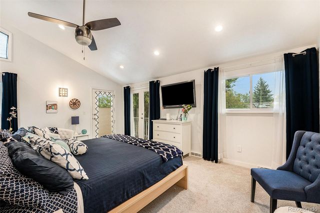 a bedroom with a bed television and a window