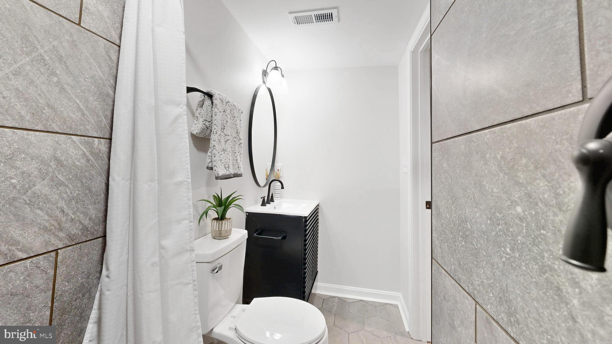 48 Girard Street Northeast Washington, DC 20002 - Photo 33 of 43 a bathroom with a granite countertop sink toilet and shower