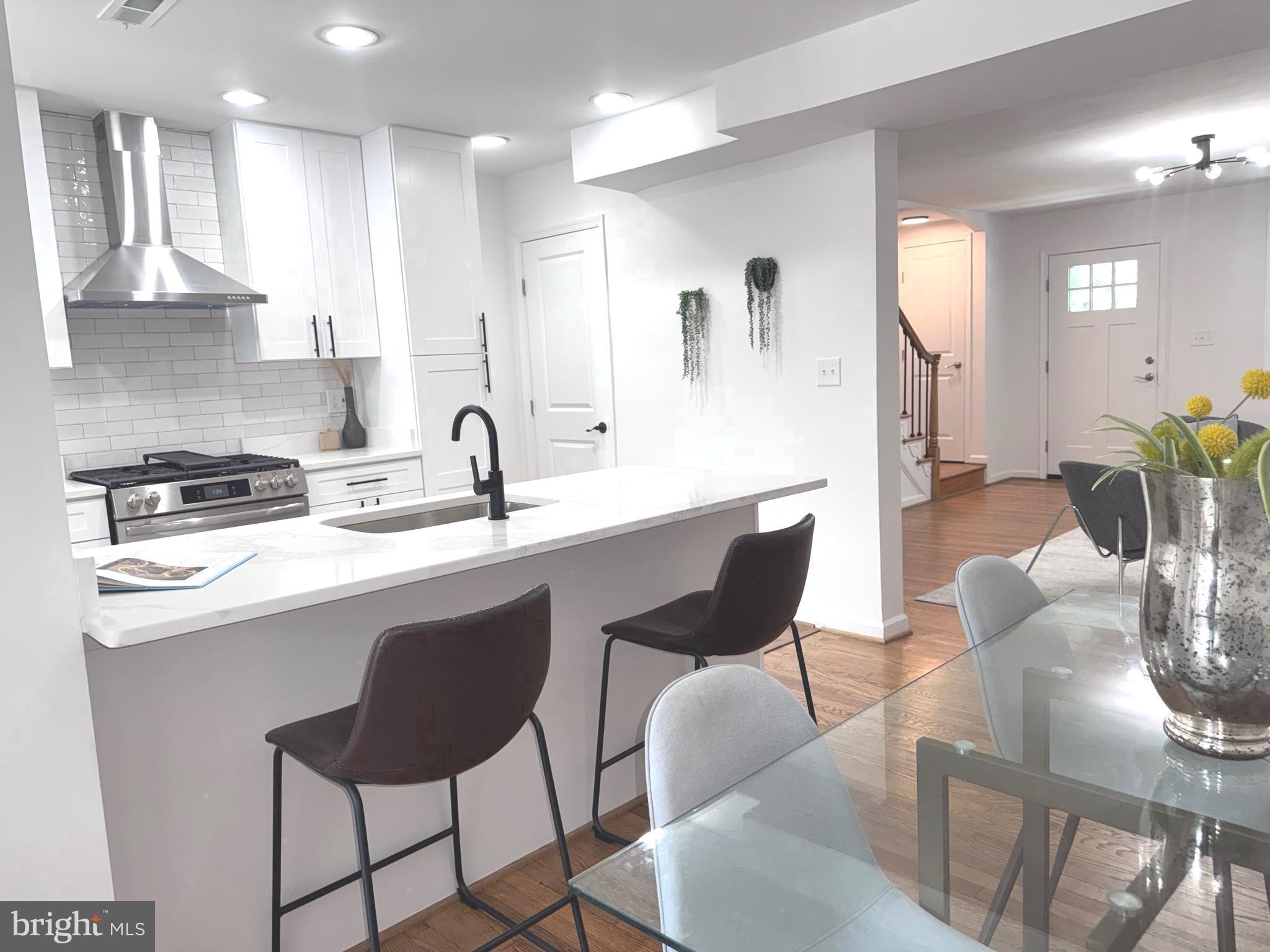 48 Girard Street Northeast Washington, DC 20002 - Photo 10 of 43 a kitchen with stainless steel appliances granite countertop a sink a stove a dining table and chairs