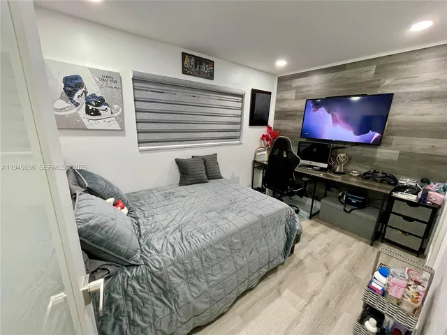 a bedroom with bed and a flat screen tv