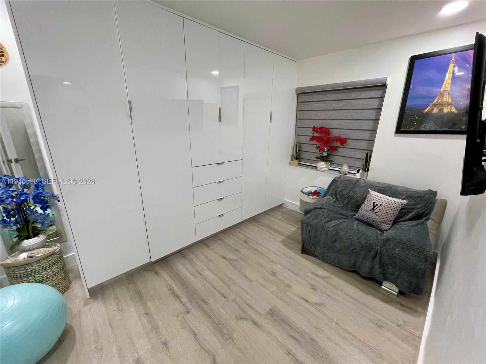 8635 Northwest 8th Street, Unit 311 Miami, FL 33126 - Photo 13 of 16 a living room with furniture and flowers