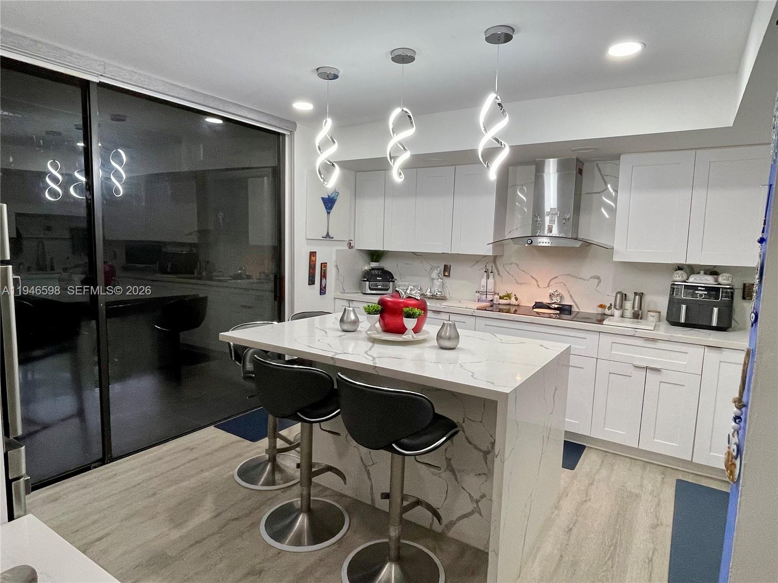 8635 Northwest 8th Street, Unit 311 Miami, FL 33126 - Photo 3 of 16 a kitchen with stainless steel appliances granite countertop a sink a stove and chairs