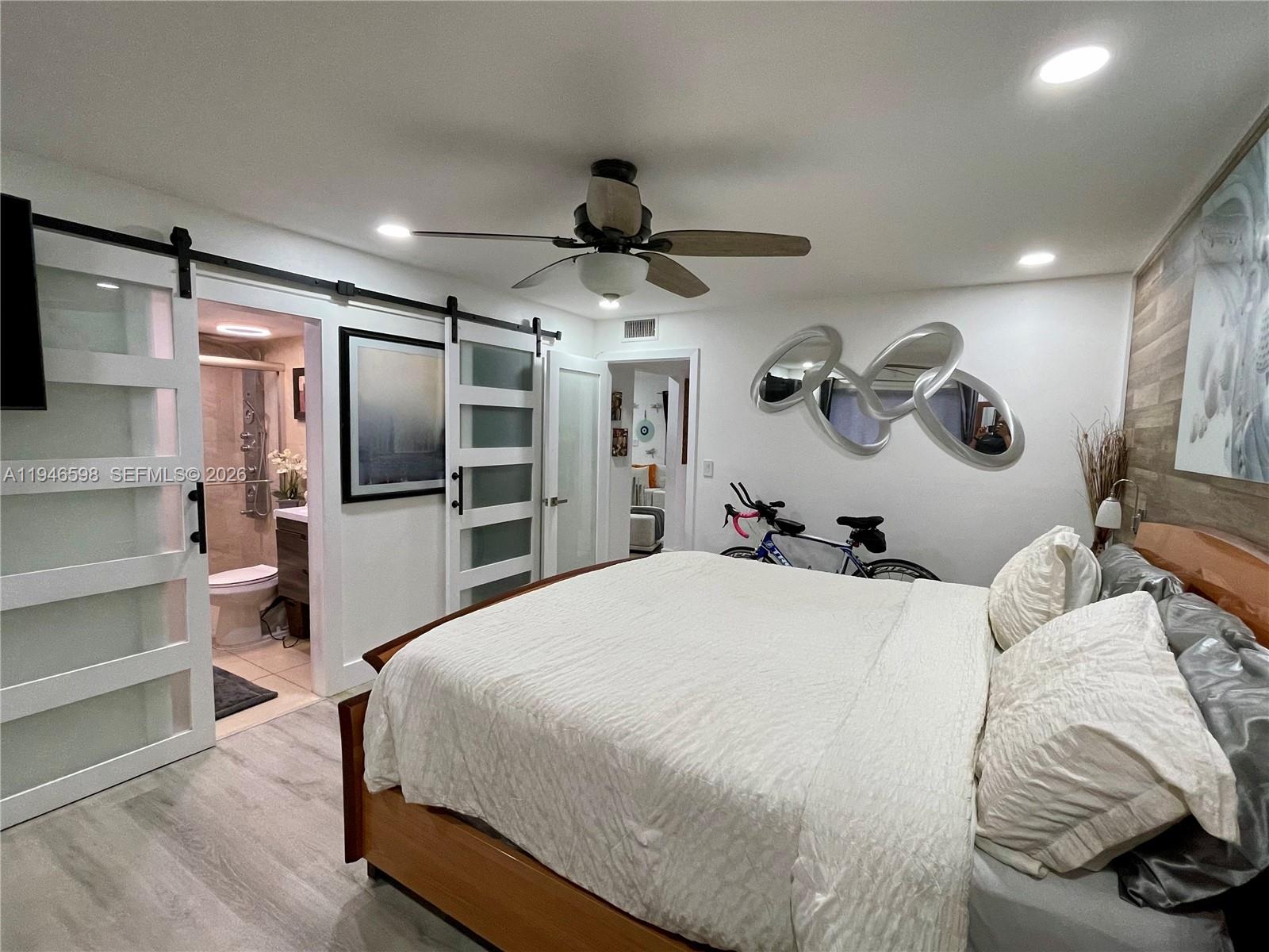 8635 Northwest 8th Street, Unit 311 Miami, FL 33126 - Photo 9 of 16 a bedroom with a bed and a flat screen tv