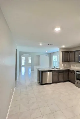 a large white kitchen with a stove a sink and a refrigerator