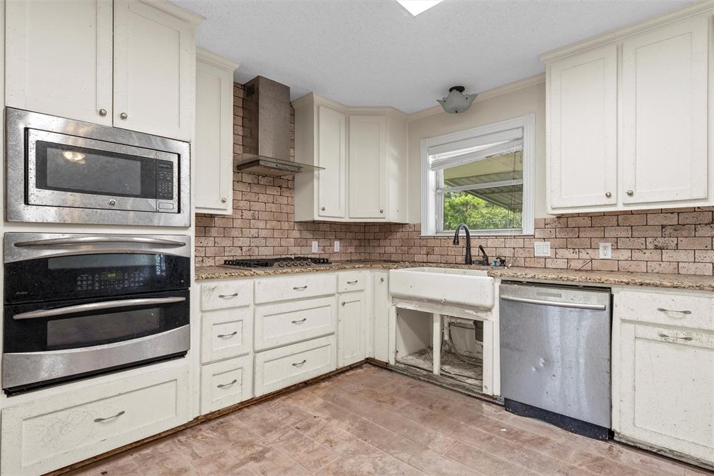 849 Deer Ridge Drive Woodway, TX 76712 - Photo 8 of 25 a kitchen with granite countertop white cabinets stainless steel appliances and sink