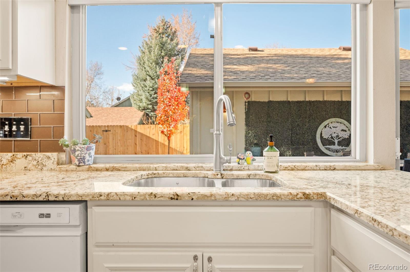 8734 Independence Way Arvada, CO 80005 - Photo 11 of 50 a bathroom with granite countertop a sink and a mirror