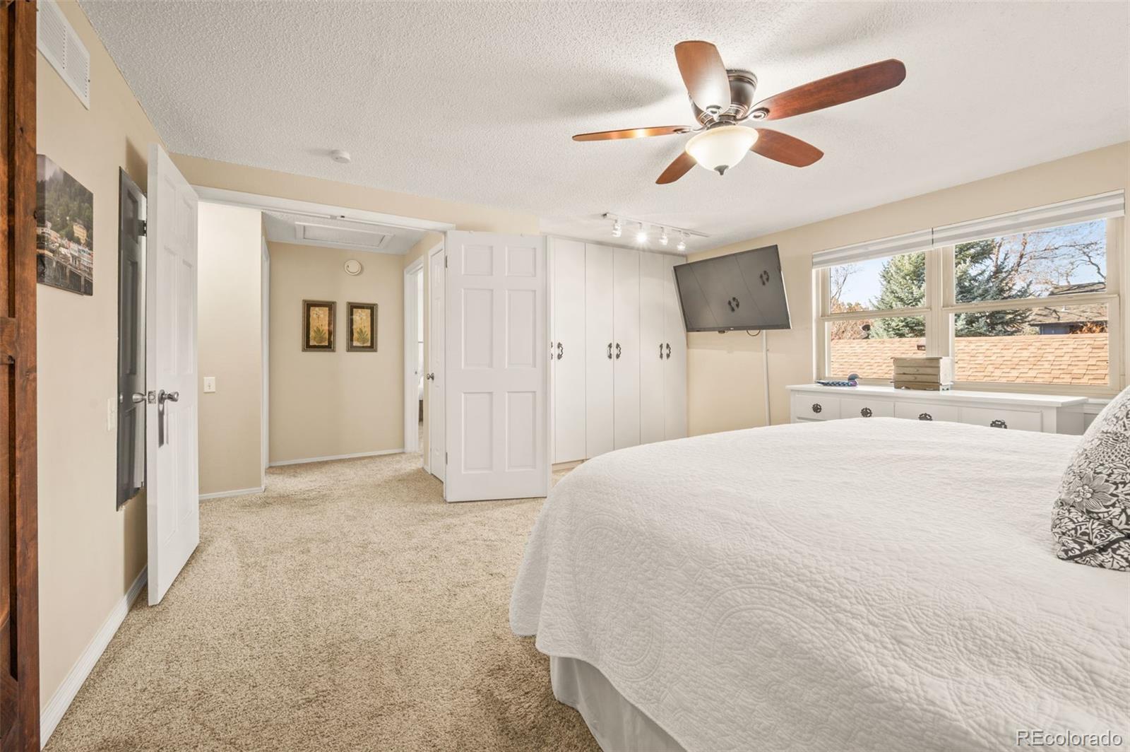 8734 Independence Way Arvada, CO 80005 - Photo 22 of 50 a spacious bedroom with a bed and a chandelier