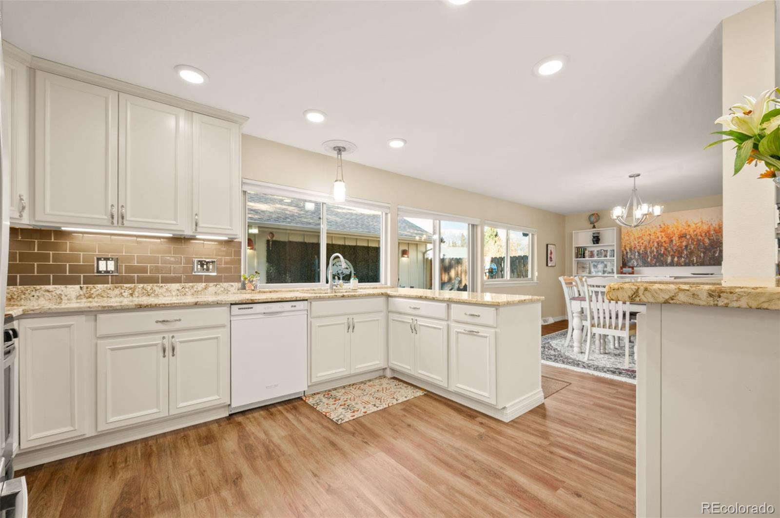 8734 Independence Way Arvada, CO 80005 - Photo 10 of 50 a kitchen with sink cabinets and wooden floor