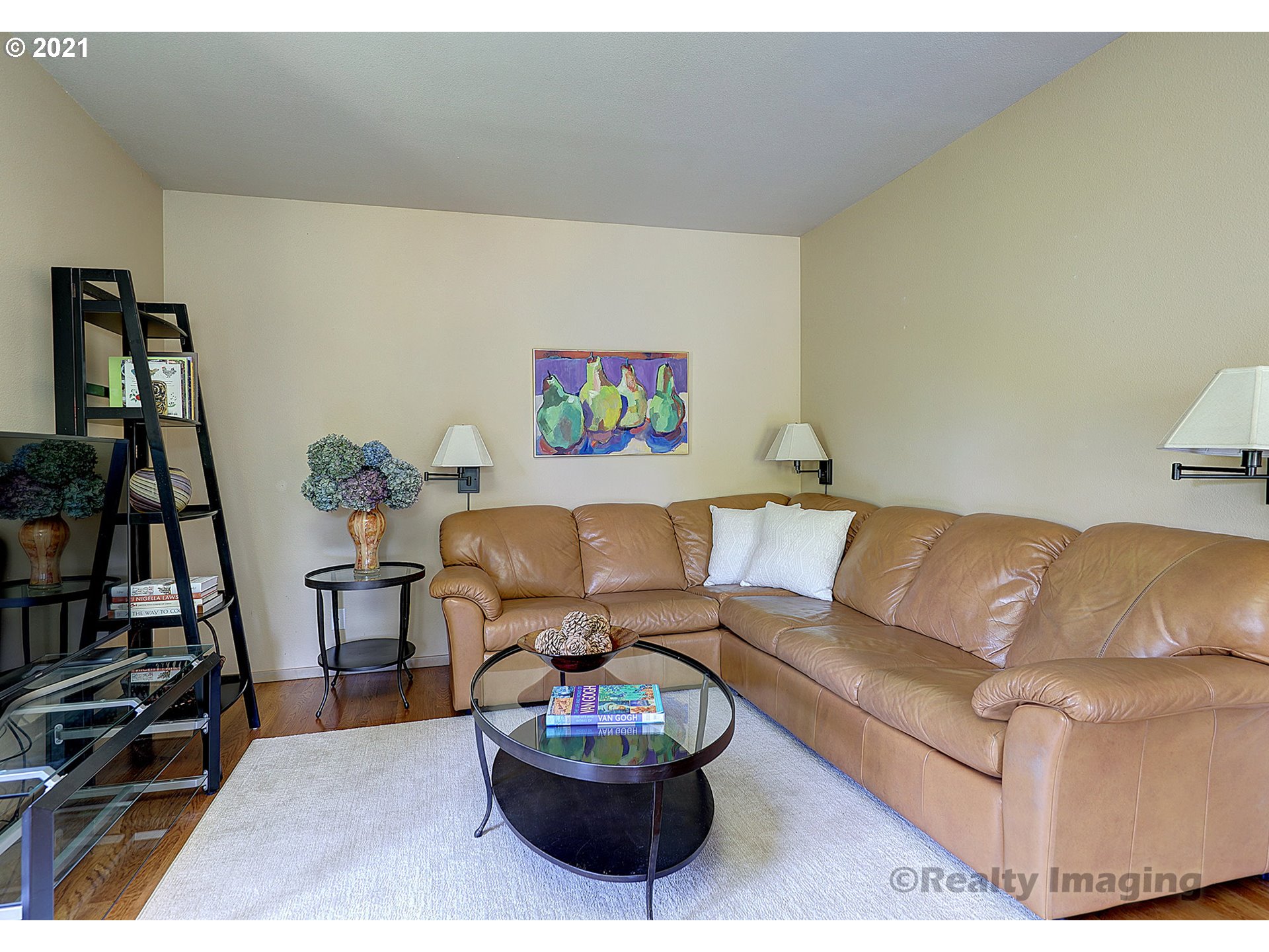 7402 Northwest Penridge Road Portland, OR 97229 - Photo 8 of 32 a living room with a couch and a bookshelf with wooden floor