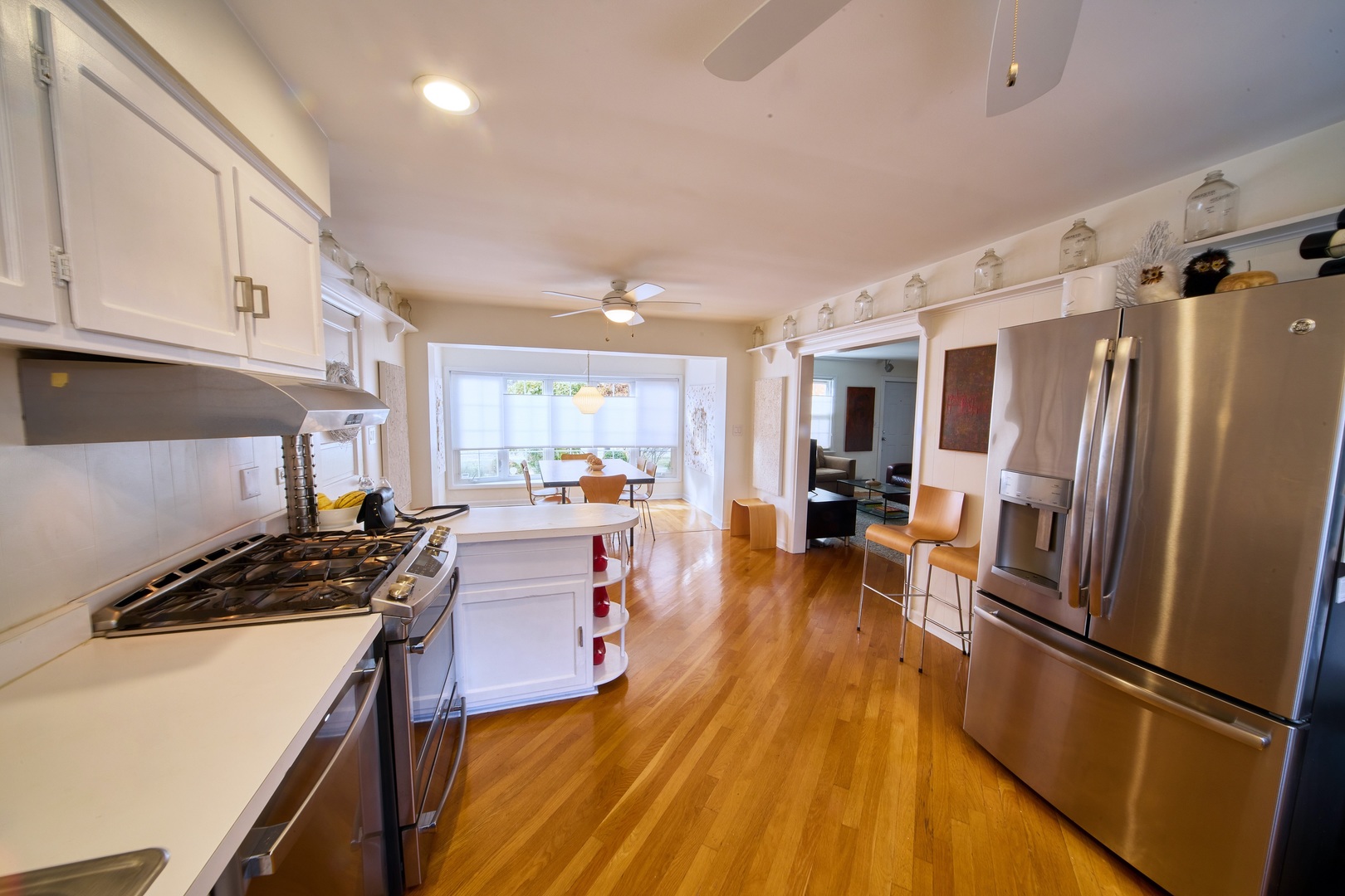5955 North Keating Avenue Chicago, IL 60646 - Photo 6 of 22 a kitchen with a refrigerator a stove and white cabinets with wooden floor