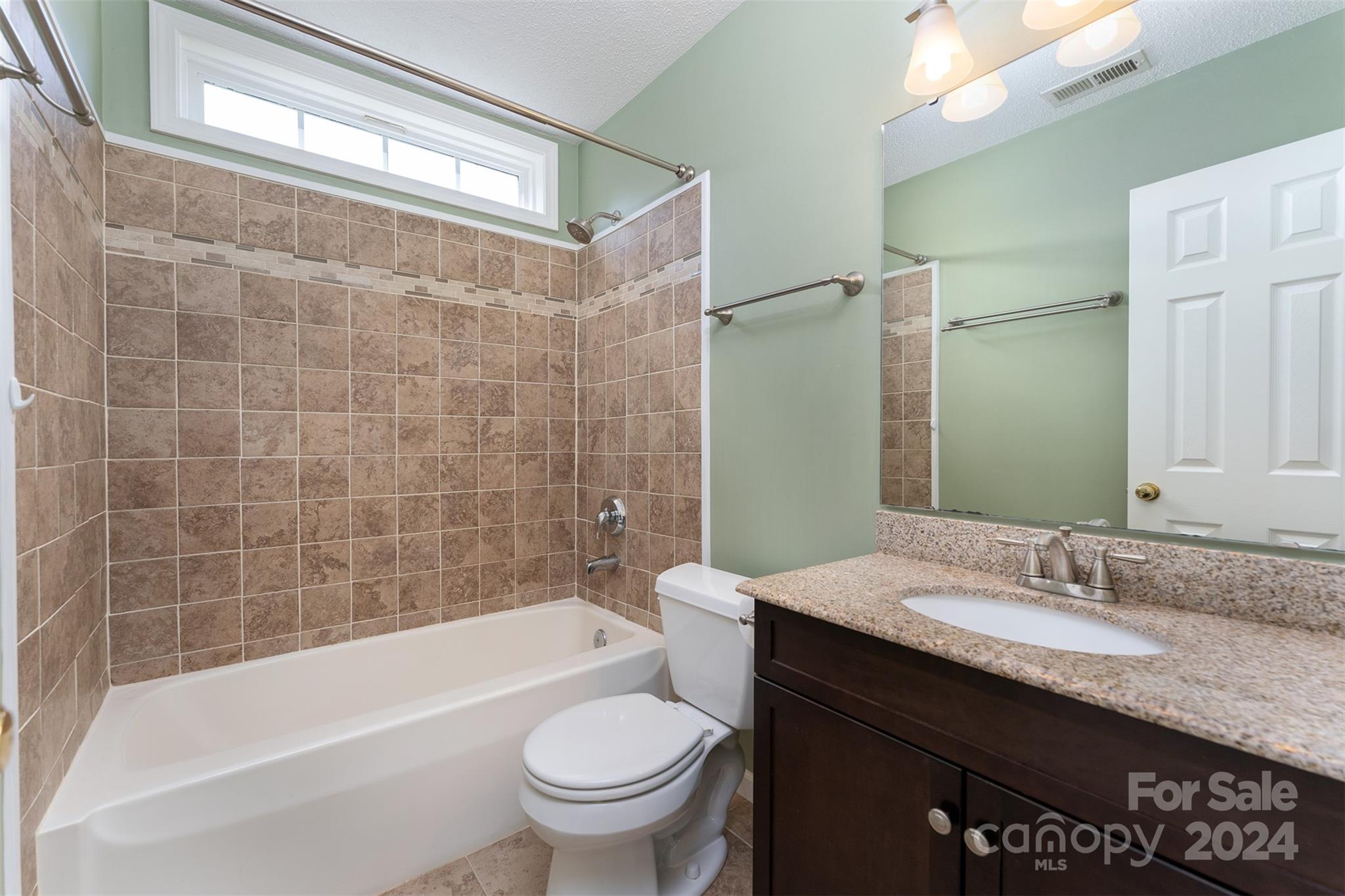 311 Planters Creek Road Fletcher, NC 28732 - Photo 16 of 24 a bathroom with a granite countertop bathtub sink vanity mirror and toilet