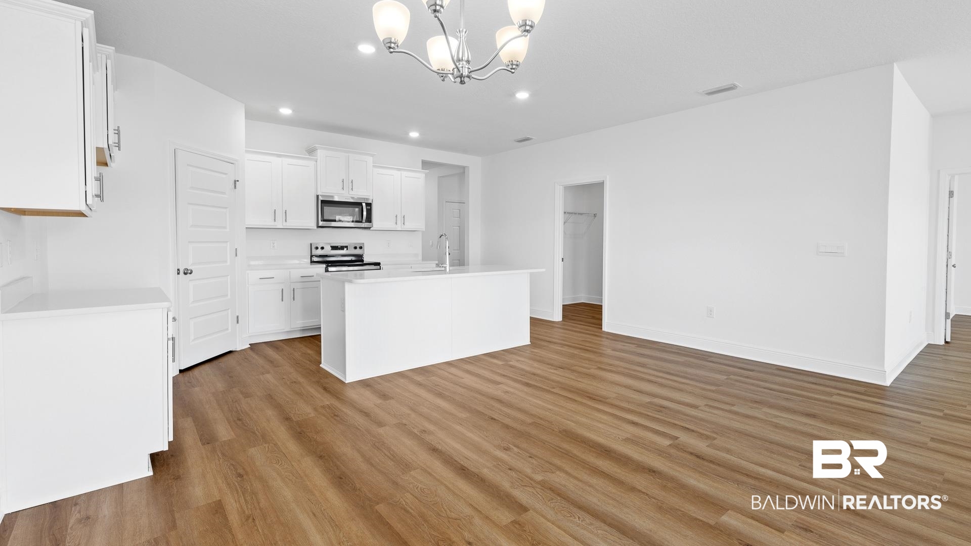 12931 Grand Rpds Road Fairhope, AL 36532 - Photo 17 of 33 Kitchen featuring light countertops, a notable chandelier, light wood-type flooring, and appliances with stainless steel finishes