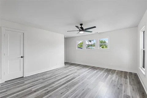 a kitchen with stainless steel appliances kitchen island granite countertop a stove a sink a refrigerator and white cabinets with wooden floor