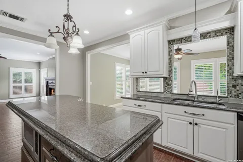 a kitchen with kitchen island granite countertop a center island a sink cabinets and wooden floor