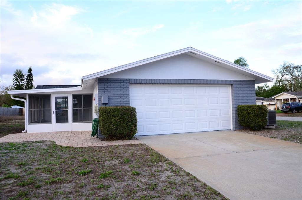 10433 Laburnum Drive Port Richey, FL 34668 - Photo 3 of 26 a front view of a house with a yard and garage