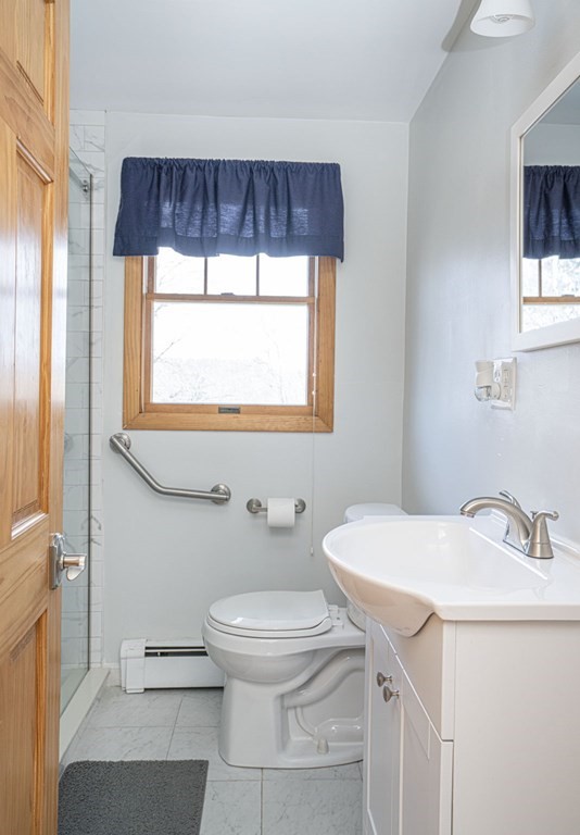 56 Spring Street Plainville, MA 02762 - Photo 15 of 21 a bathroom with a sink a toilet and a window