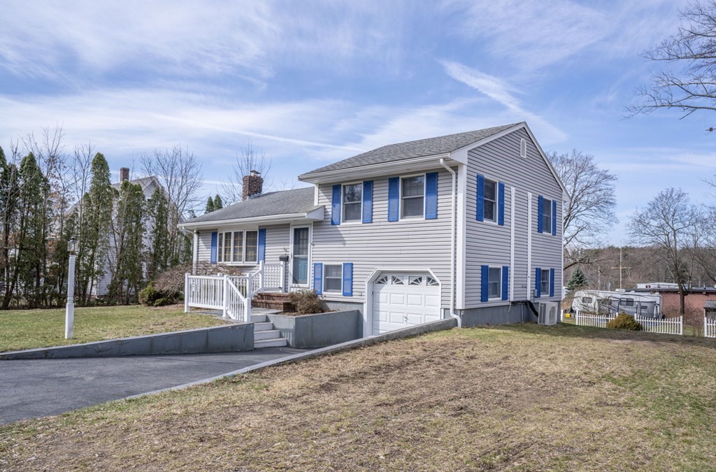 56 Spring Street Plainville, MA 02762 - Photo 3 of 21 a front view of a house with a yard and garage