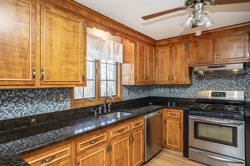 56 Spring Street Plainville, MA 02762 - Photo 8 of 21 a kitchen with stainless steel appliances granite countertop a sink a stove cabinets counter space and a window