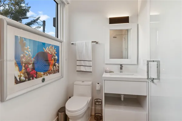 a bathroom with a toilet a sink and mirror