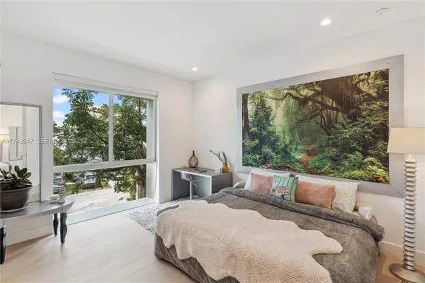 a bedroom with a large bed and a large window
