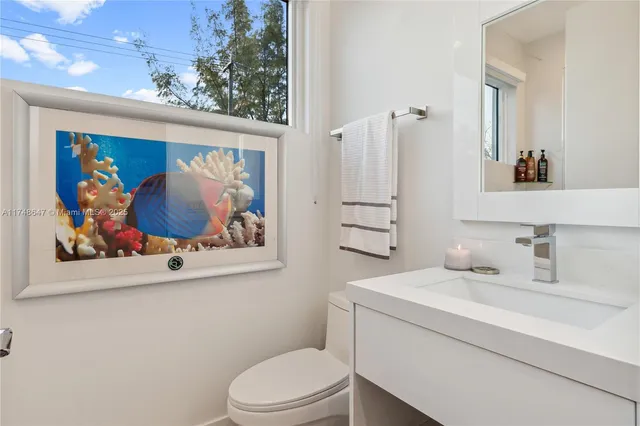 a bathroom with a toilet a sink and wooden floor