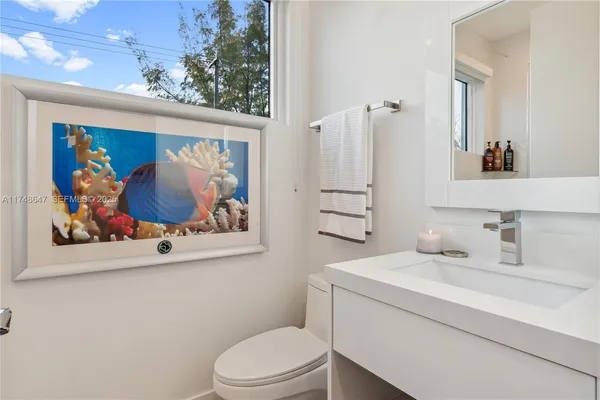 a bathroom with a toilet a sink and wooden floor