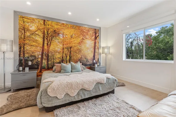 a bedroom with a large bed and a large window