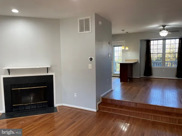 a living room with wooden floors and a fireplace