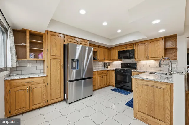 a kitchen with a refrigerator sink and cabinets