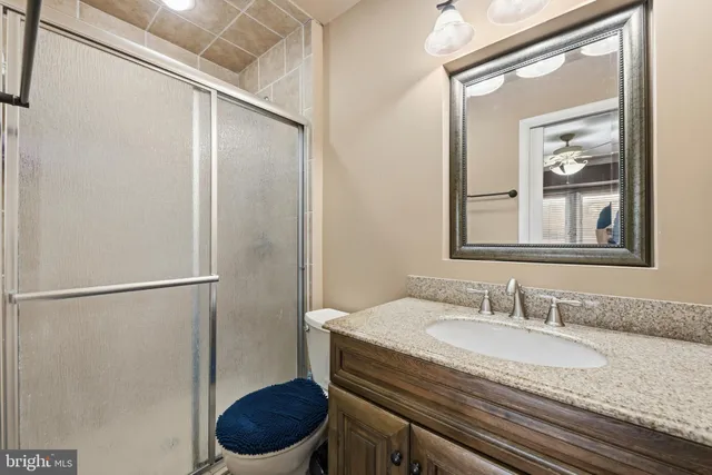 a bathroom with a granite countertop sink toilet and a mirror