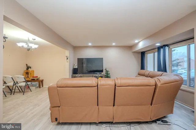 a living room with furniture a flat screen tv and a large window