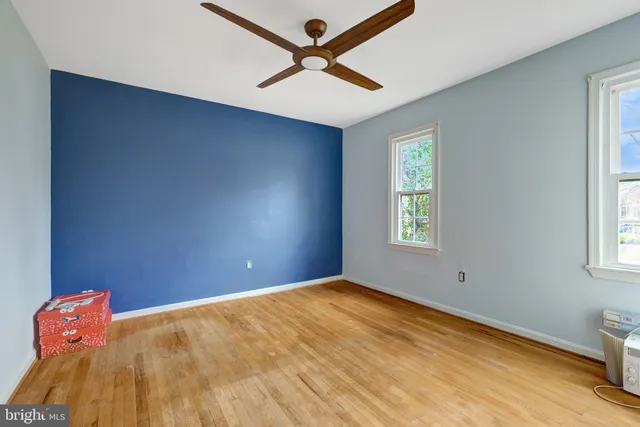 a view of empty room with window and ceiling fan