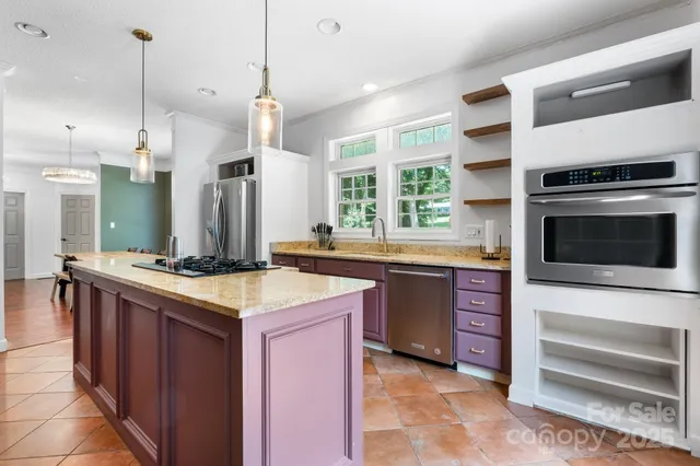 a kitchen with a stove kitchen island and stainless steel appliances