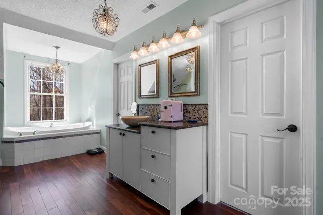 a bathroom with a granite countertop sink mirror and window