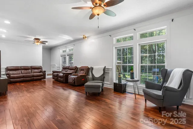 a living room with furniture ceiling fan and a window