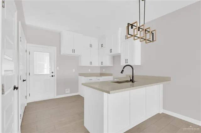 a kitchen with granite countertop white cabinets and a sink