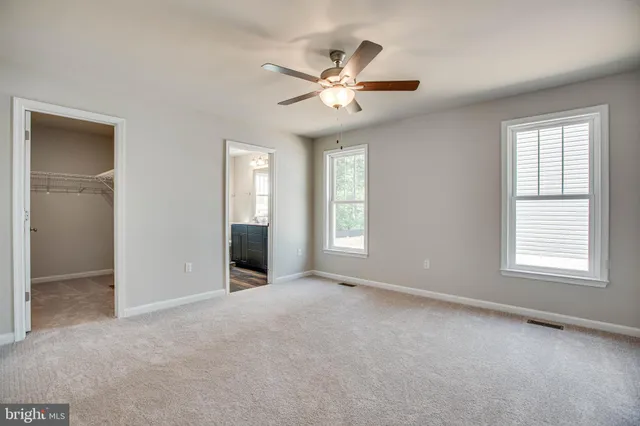 a bathroom with a granite countertop sink a toilet a mirror and a window