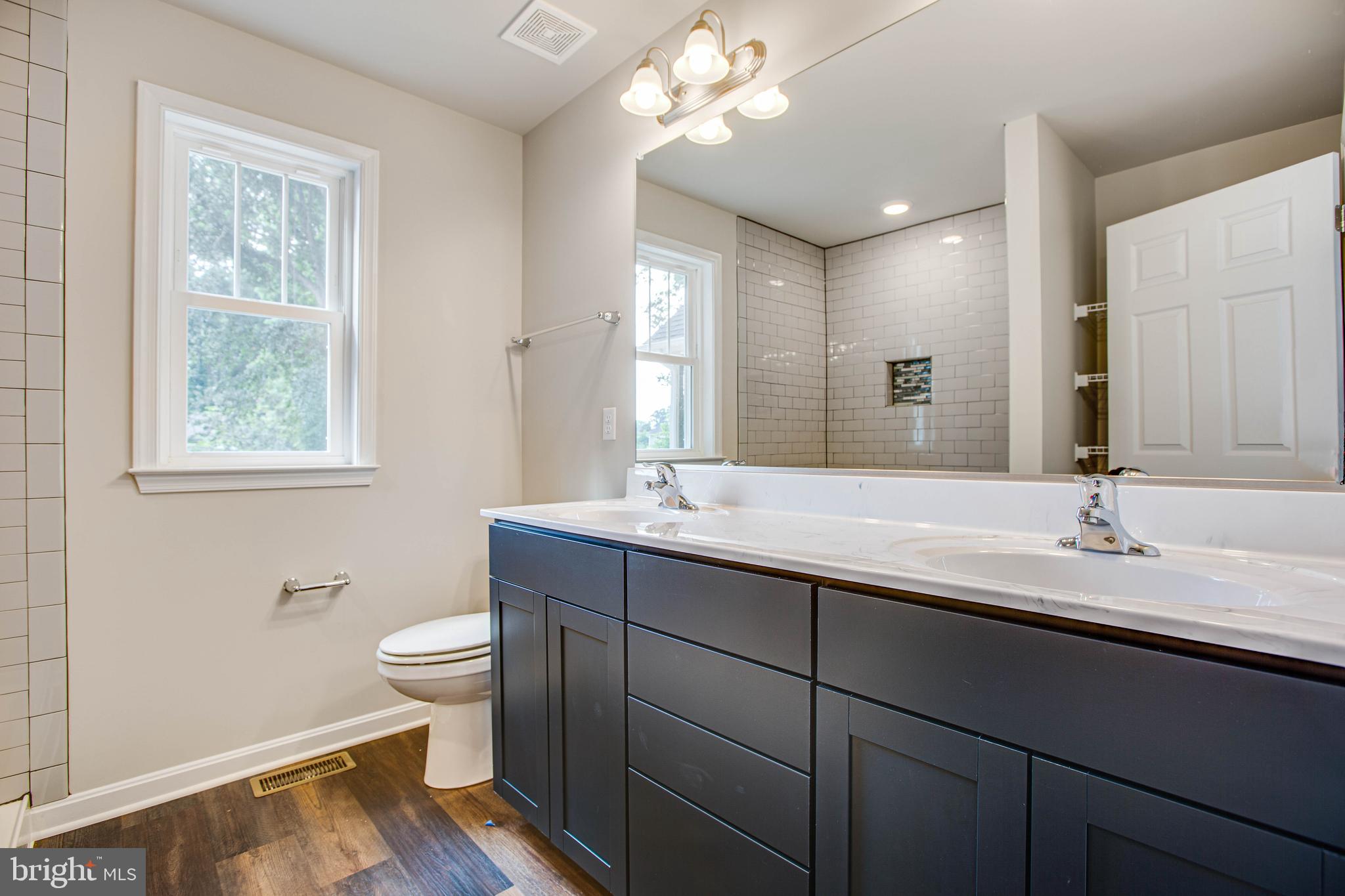 2 Ferry Landing Colonial Beach, VA 22443 - Photo 15 of 62 a bathroom with a granite countertop sink a toilet a mirror and a window