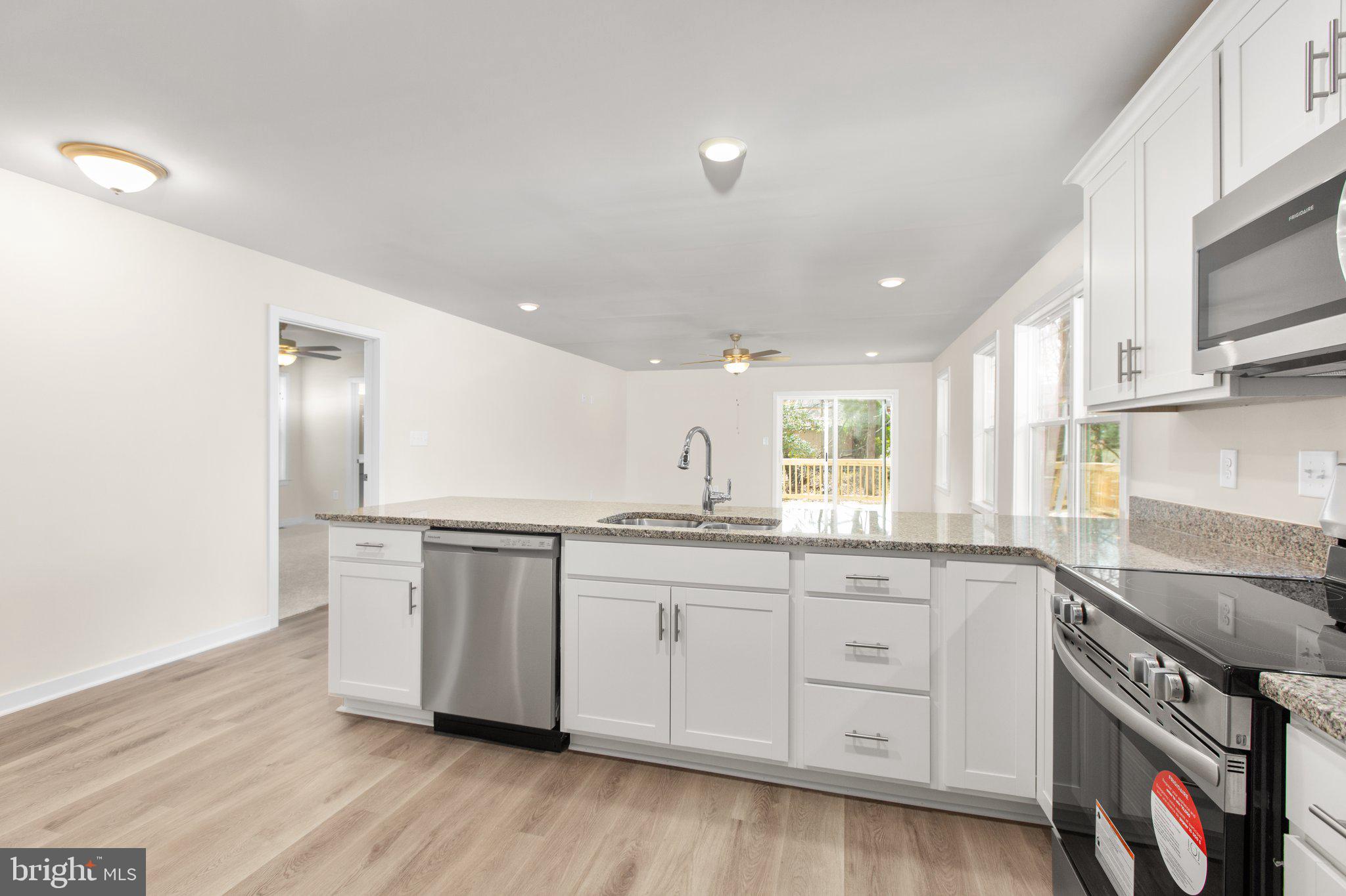 2 Ferry Landing Colonial Beach, VA 22443 - Photo 36 of 62 a kitchen with granite countertop white cabinets and wooden floor
