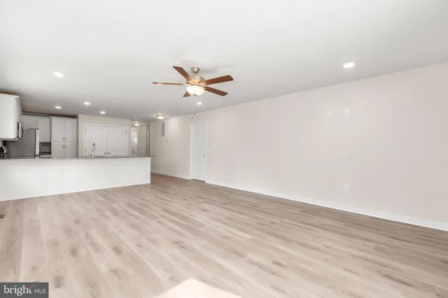 an empty room with a window and a ceiling fan