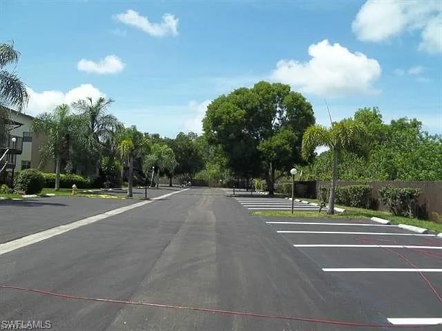 5270 Treetops Drive, Unit J201 Naples, FL 34113 - Photo 2 of 6 View of asphalt road featuring street lights