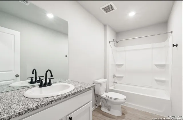 a bathroom with a sink a toilet and a mirror