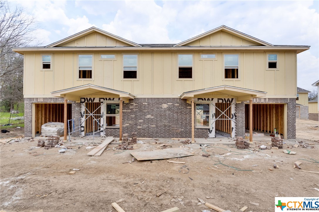 a view of a white house with large trees and outdoor space