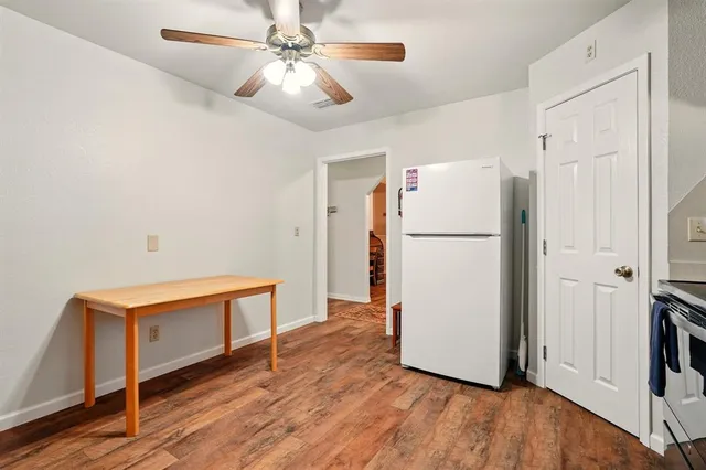 a view of kitchen with refrigerator and wooden floor